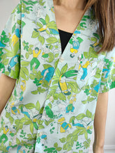 Lade das Bild in den Galerie-Viewer, Die blaugrüne Bluse mit Dschungelmuster | Vintage Blumen Fleurs Tier Papagei Vögel Menschen Crazy Print Kurzarm Damen Shirt M
